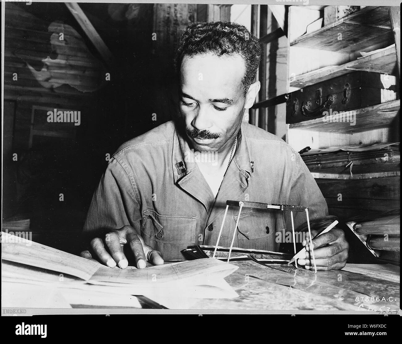 Le capitaine Eugene C. Cheatham de Montclair, New Jersey, servant avec le cinquième de l'Armée de l'air 67e Escadre de reconnaissance tactique à un stade avancé de la base aérienne de Corée, est montré l'étude des photographies aériennes prises par photo-reconn appareils de la 67e Escadre. Il va interpréter les informations sur les impressions, un rapport à l'état-major supérieur, qui attribue à des cibles de chasse de la Force aérienne tactique Cinquième chasseur-bombardier, bombardier léger et unités pour lutter contre les grèves. Banque D'Images