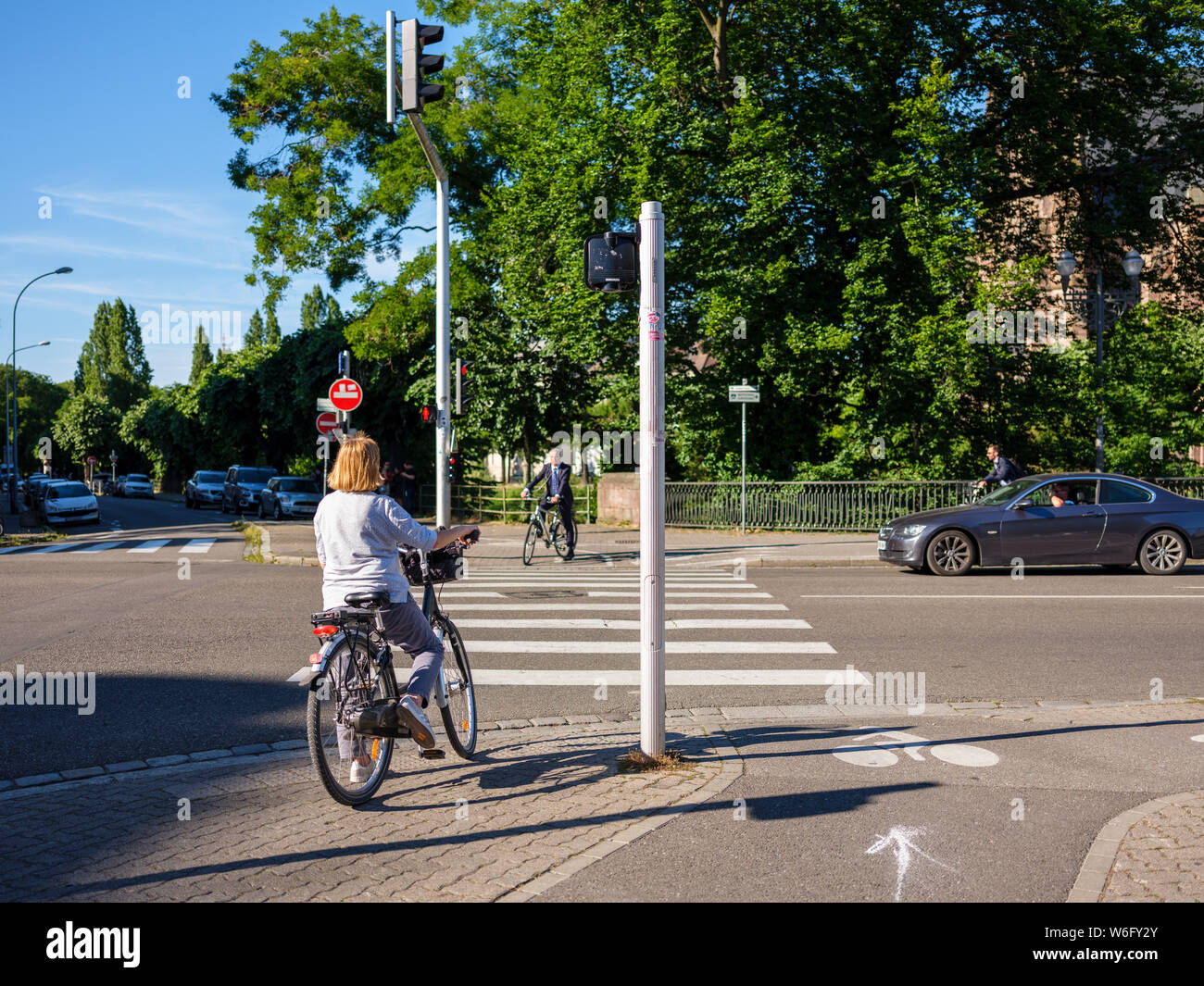 Les cyclistes en attente de rue transversale au passage pour piétons, Strasbourg, Alsace, France, Europe, Banque D'Images