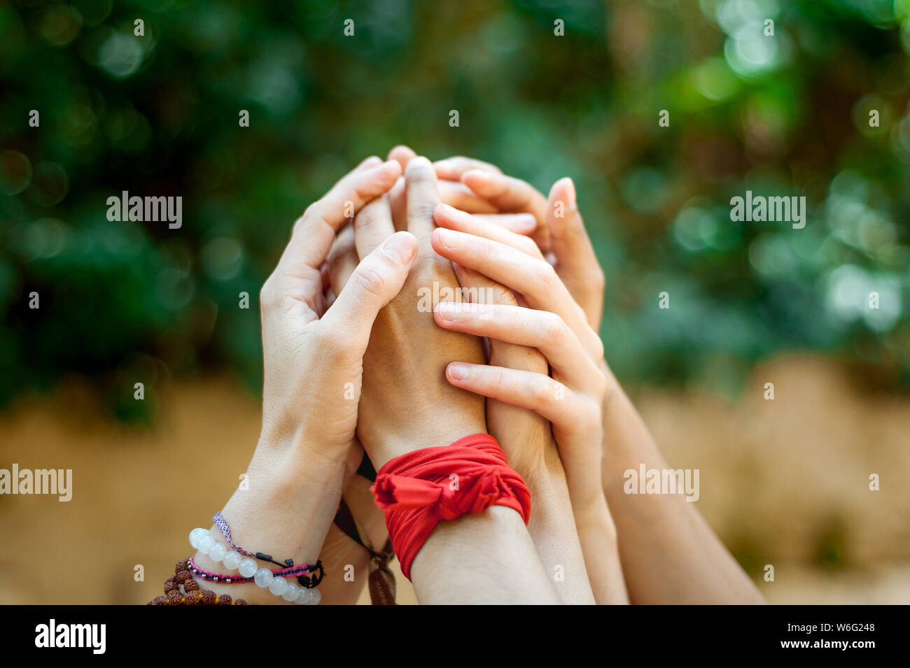 Portrait de groupe de femmes mains en l'air mains tenant serré l'un l'autre comme un symbole du féminisme et des bracelets avec connexion féminin Banque D'Images