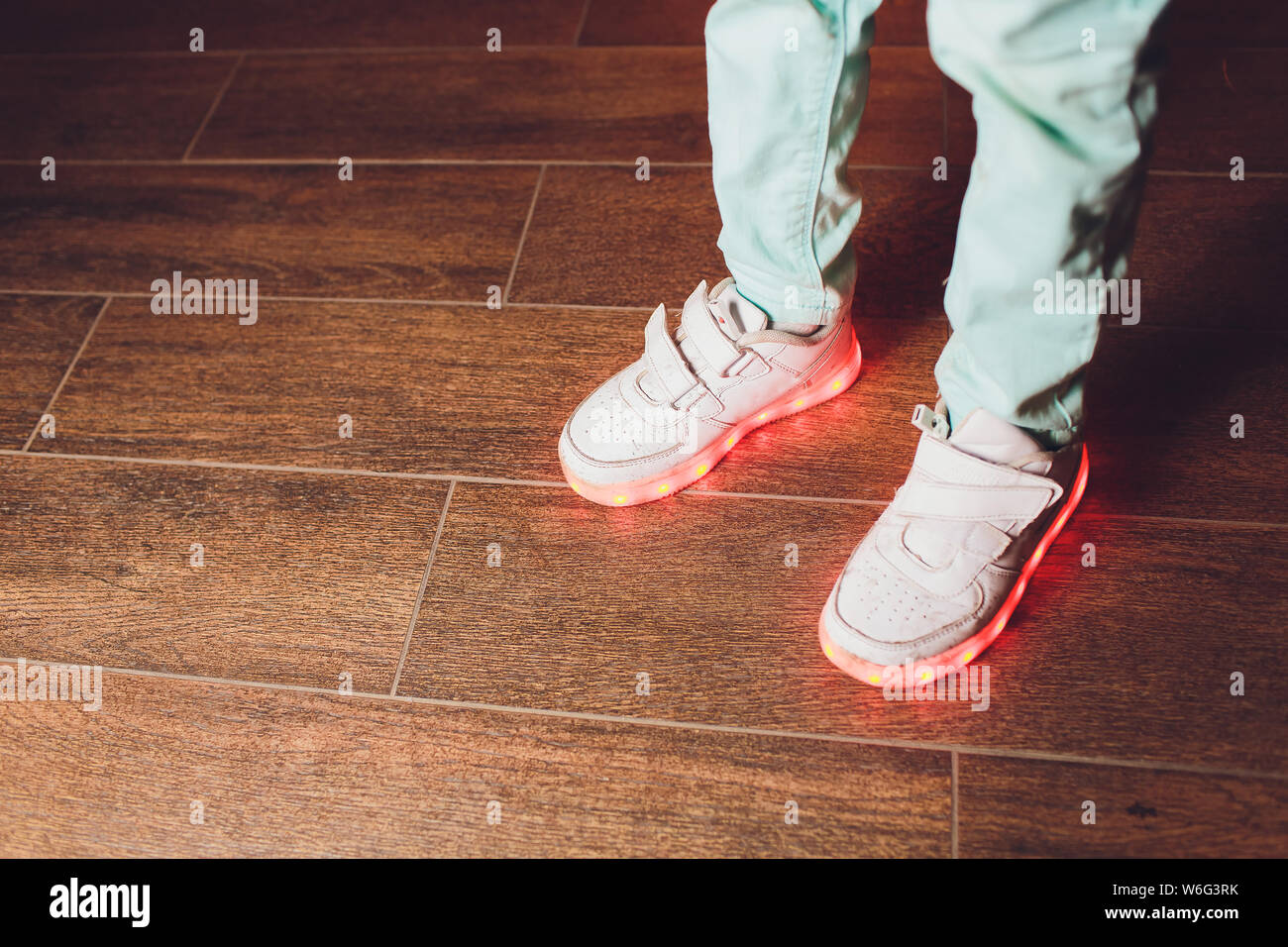 La mode des chaussures avec éclairage LED sur les jambes d'une fille . La  même couleur de l'éclairage LED sneakers.cadre vertical Photo Stock - Alamy