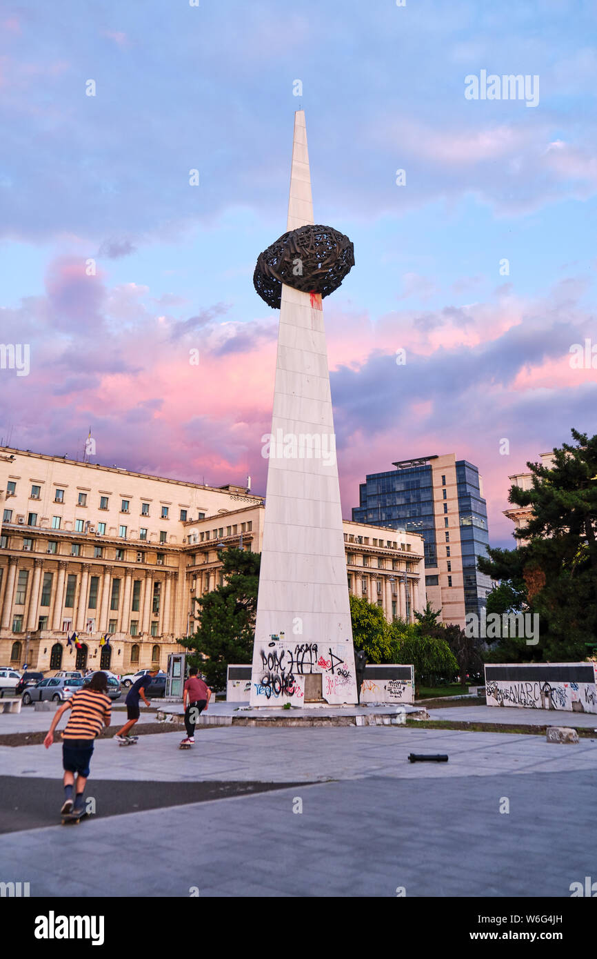 Bucarest, Roumanie - 24 juillet 2019 : Mémorial de la Renaissance (Memorialul Renasterii), au coucher du soleil, avec des patineurs faisant des tours près de l'Avenue de la Victoire (Calea Victo Banque D'Images