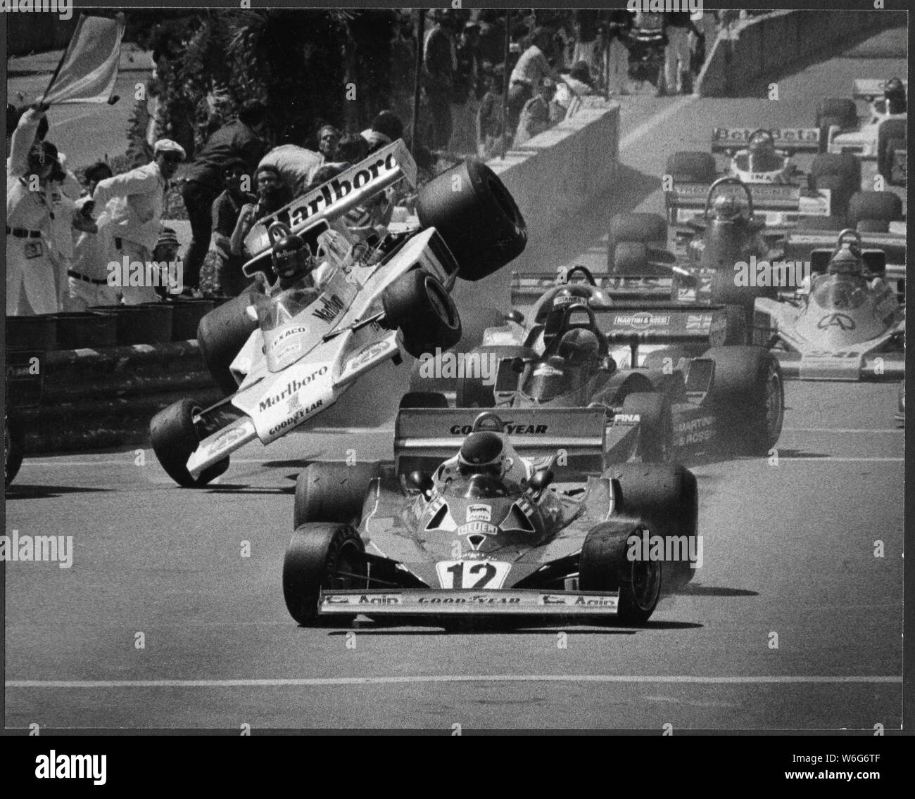 US Grand Prix de Formule 1, 1977, Long Beach en Californie avec la fin pilote James Hunt de l'Angleterre (mort en 1993), F1 world champion de conduite sur une roue après l'accident du premier tour au premier tour avec un 4 roues Tyrell , derrière # 12 Ferrari de Gilles Villeneuve (mort en 1982) du Canada, lauréat avait entraîné par - Mario Andretti - Hunt était hors de la race de ce contact dans sa McLaren, numérisation de l'original 8x10 caractères. Simon James Wallis Hunt était un pilote automobile britannique qui a remporté le Championnat du Monde de Formule 1 en 1976. Après avoir pris sa retraite de la compétition en 1979, Hunt est devenu un commentateur des médias et busin Banque D'Images