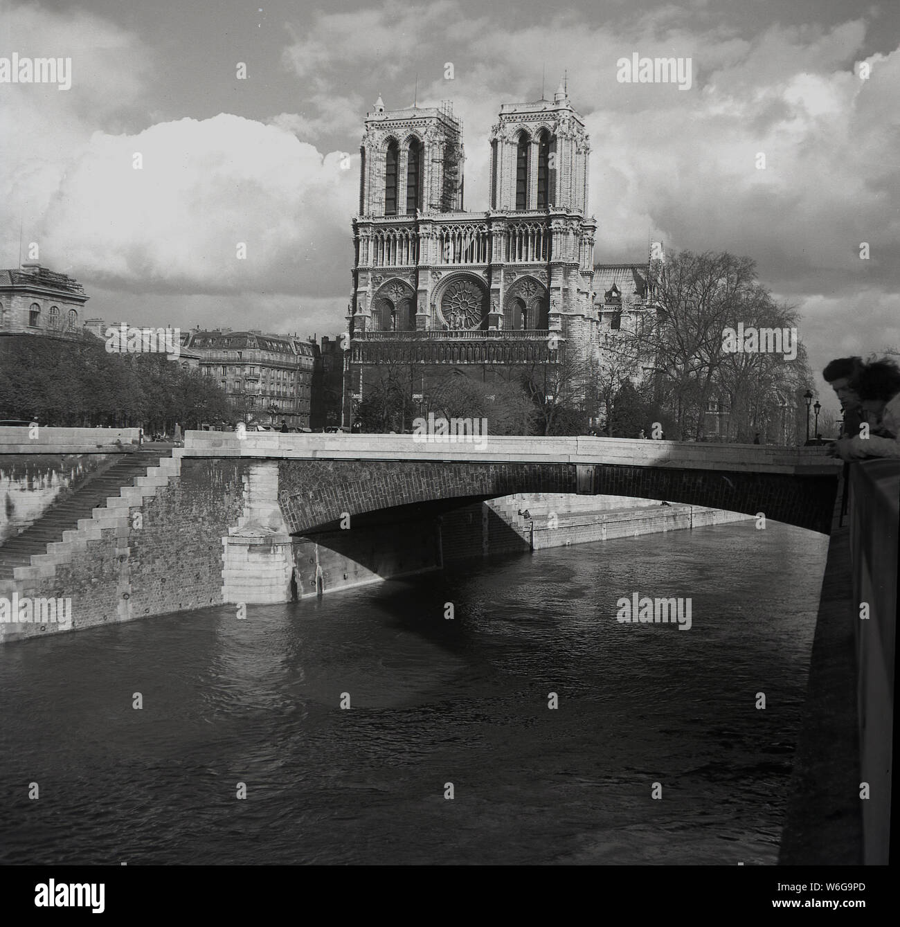 Années 1950, historique, la cathédrale Notre-Dame comme vu à partir de la Seine, Paris, France. Une église catholique médiévale sur l'IIe de la Cité dans le 4ème arrondissement de Paris, il est considéré comme l'un des plus beaux exemples de l'architecture gothique française. Banque D'Images