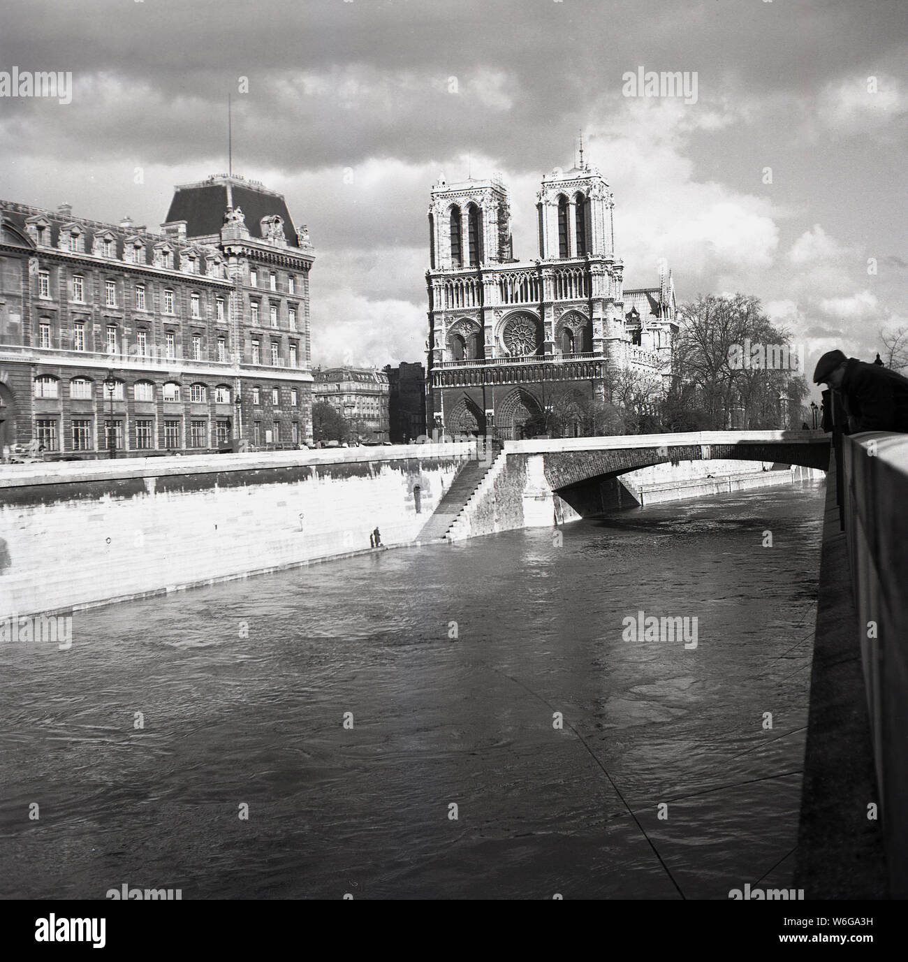 Années 1950, historique, la cathédrale Notre-Dame comme vu à partir de la Seine, Paris, France. Une église catholique médiévale sur l'IIe de la Cité dans le 4ème arrondissement de Paris, il est considéré comme l'un des plus beaux exemples de l'architecture gothique française. Banque D'Images