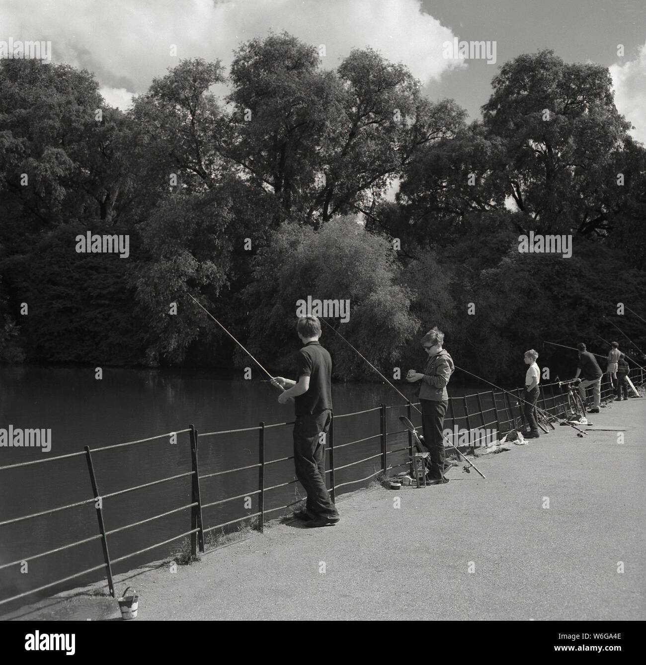 Années 1960, historiques, des jeunes gens de la pêche sur le pont de la Serpentine Serpentine Lake à Hyde Park, Londres, UK. Banque D'Images