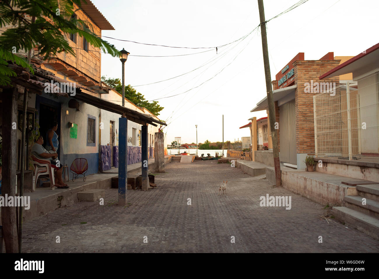 Scène de rue avec des gens assis à l'extérieur de leur maison dans le petit village de l'île de Mexcaltitán, Nayarit, Mexique, Juillet 2019 Banque D'Images