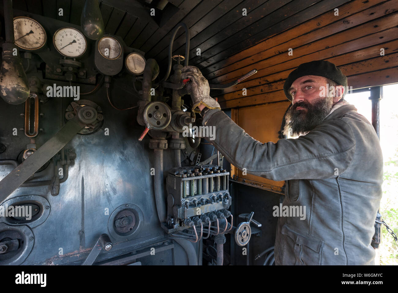 Le conducteur de train près de la chaudière de la locomotive à vapeur garde un œil sur la pression de vapeur Banque D'Images