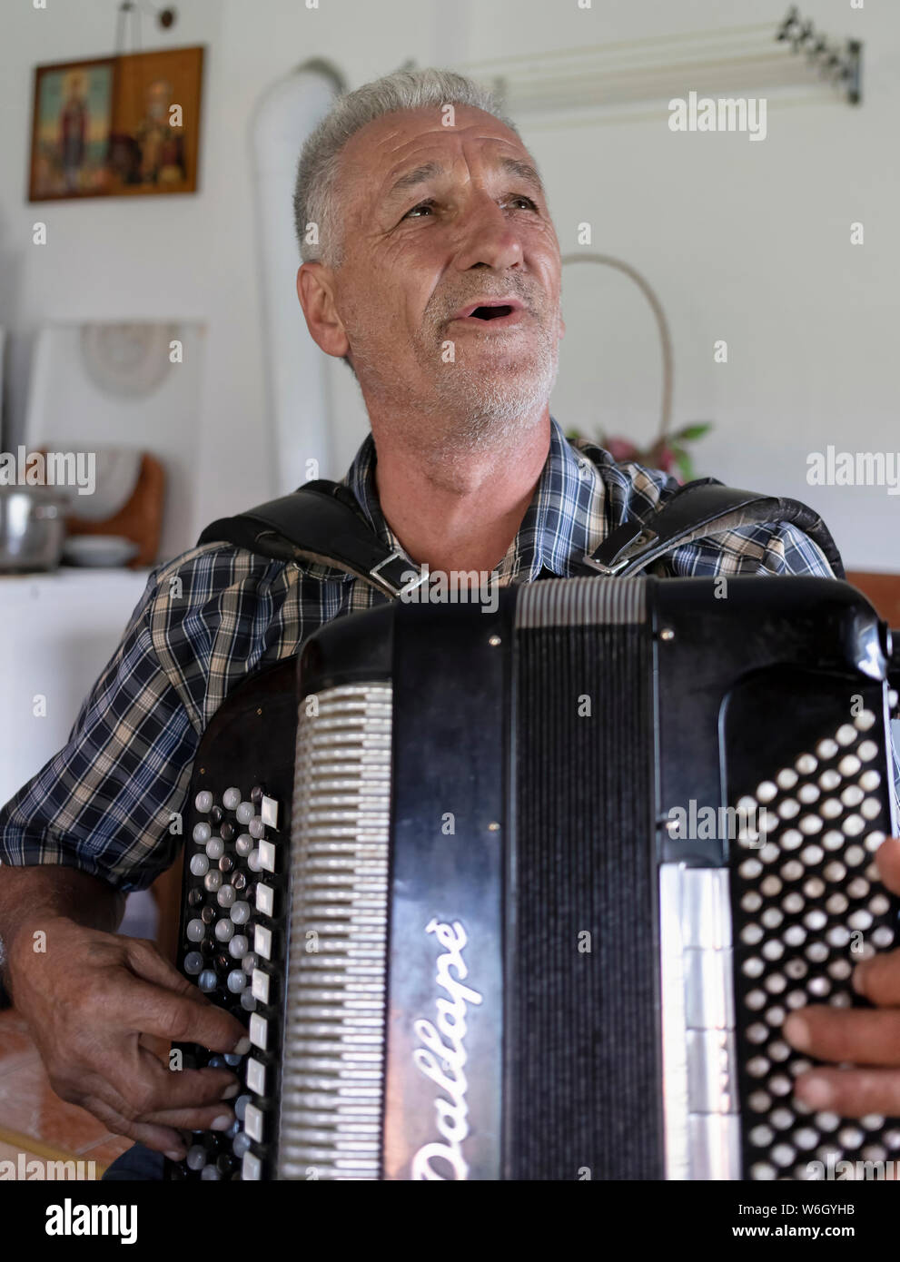 Serbie, 20 juillet 2019 : Portrait d'un homme à l'harmonica et le chant à son domicile dans le village de Solotuša Banque D'Images