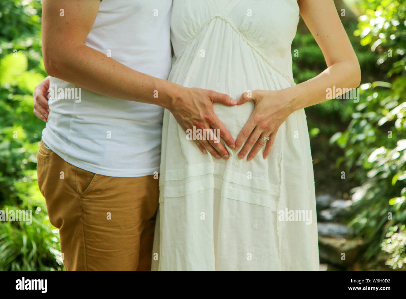 La femme enceinte et son partenaire se faisant passer pour le cœur, avec leurs mains. Symbole de la maternité, la famille, les soins et l'amour. Banque D'Images