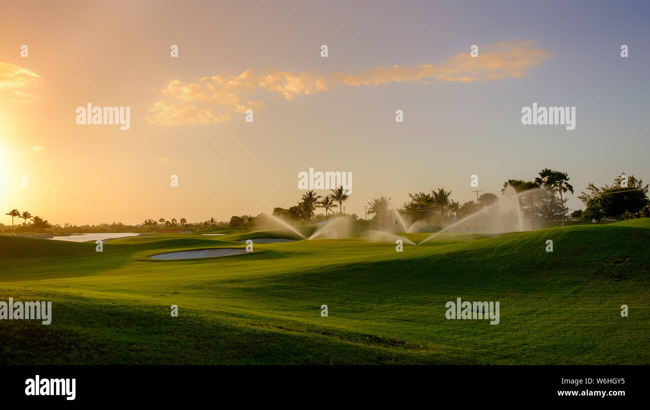 Terrain de golf au coucher du soleil sur Grand Cayman étant l'eau, îles Caïman Banque D'Images