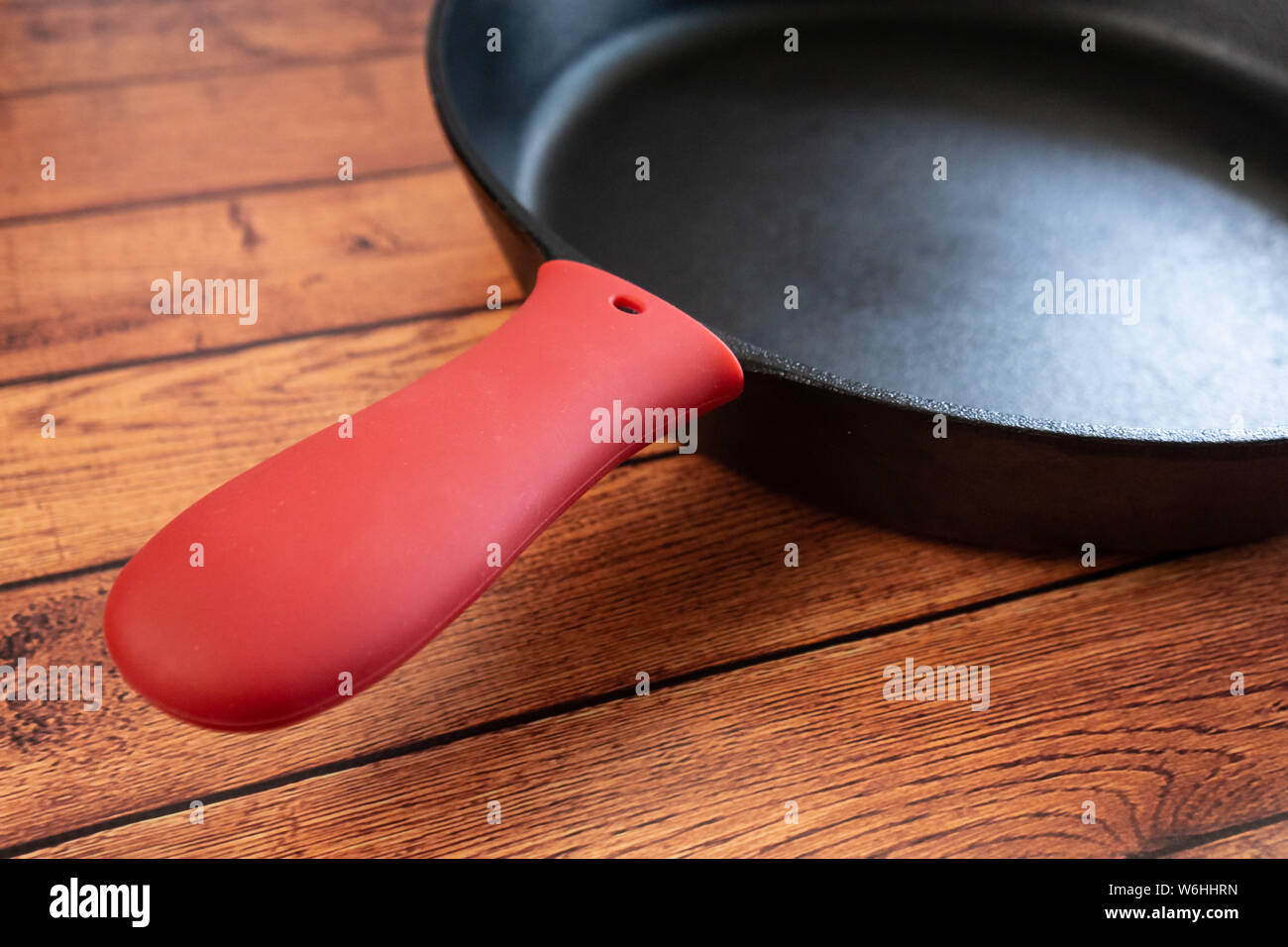Protéger de brûler les mains avec un couvercle en silicone pour votre poêle en fonte ou une poêle. Brûler la protection contre les accidents de cuisson. Close up de poignée avec re Banque D'Images