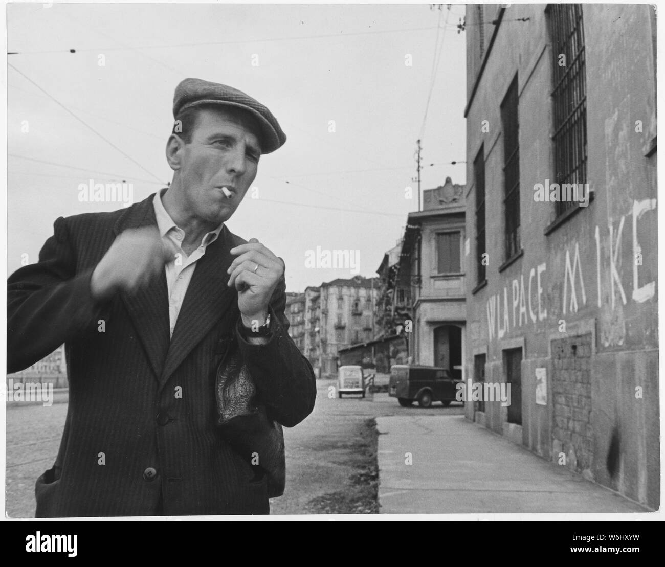 L'Italie. [Un homme de fumer une cigarette. Sur le mur l'inscription lit jusqu'à la paix, vers le bas avec Ike (Eisenhower)]. Banque D'Images