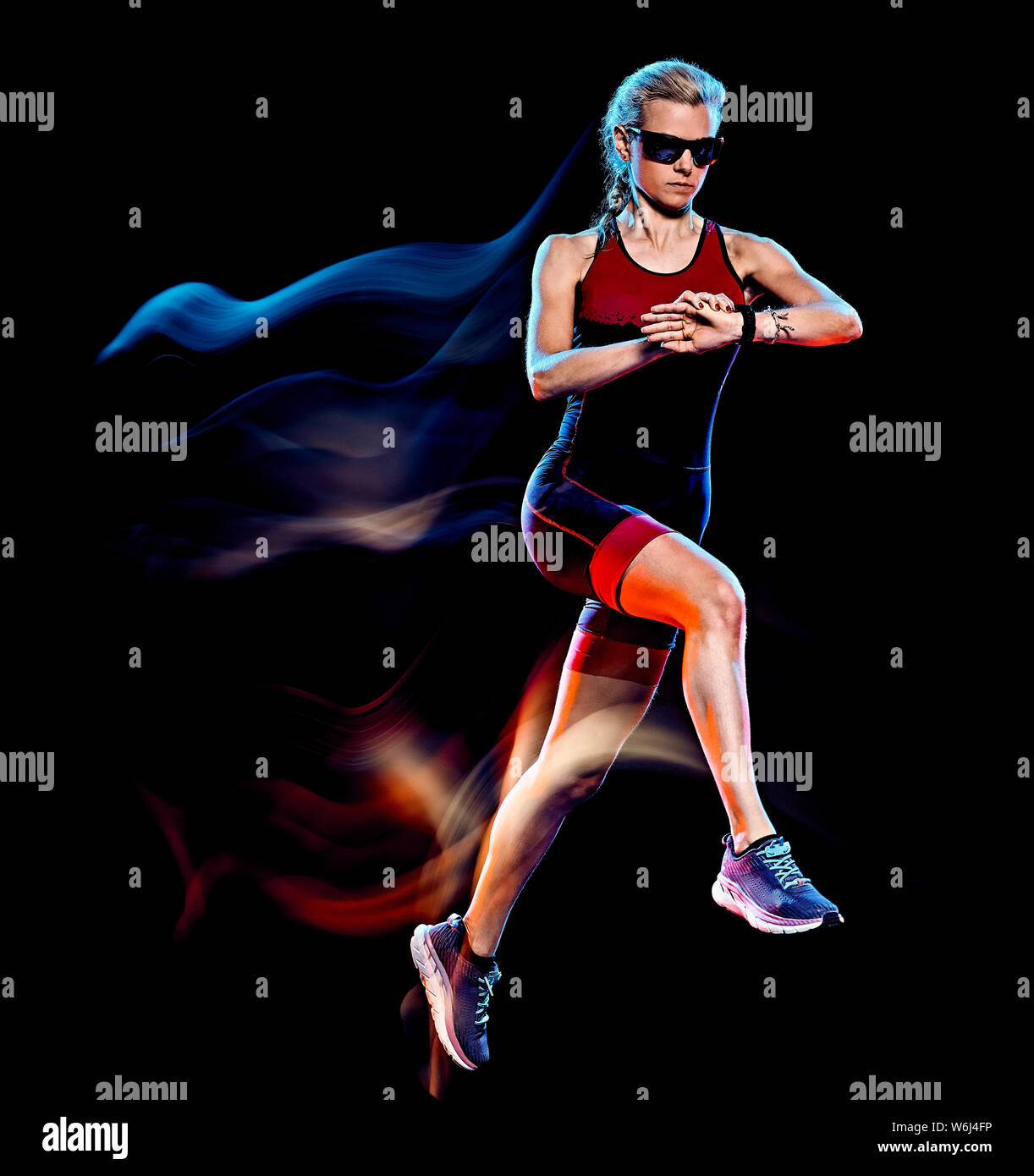 Un triathlète triathlon woman runner running jogging joogger studio shot isolé sur fond noir avec effet light painting Banque D'Images