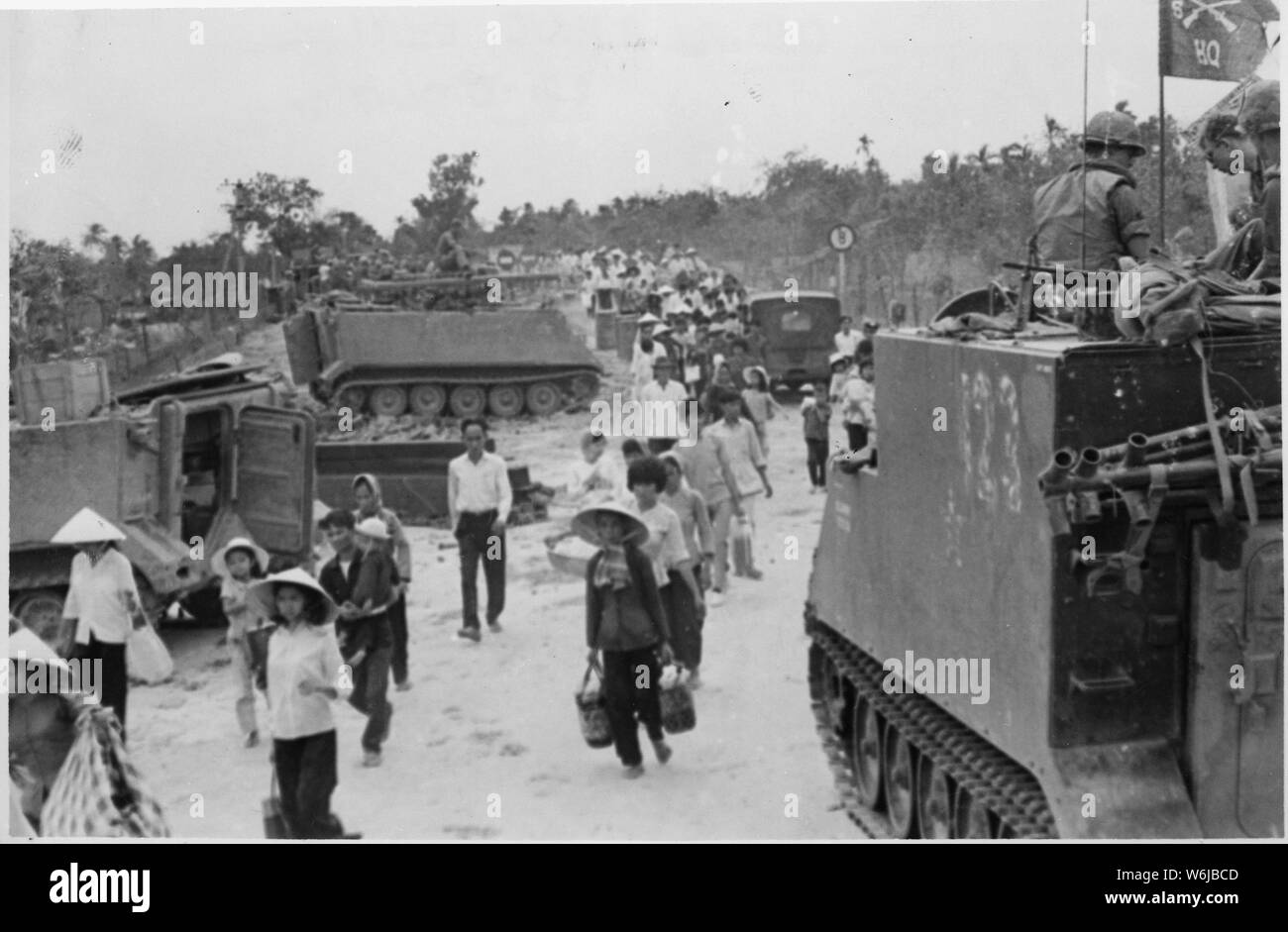 M-113 blindés stand by comme réfugiés vietnamiens à évacuer le village de My Tho, Dinh Tuong Province au cours de l'Offensive du Têt. Banque D'Images