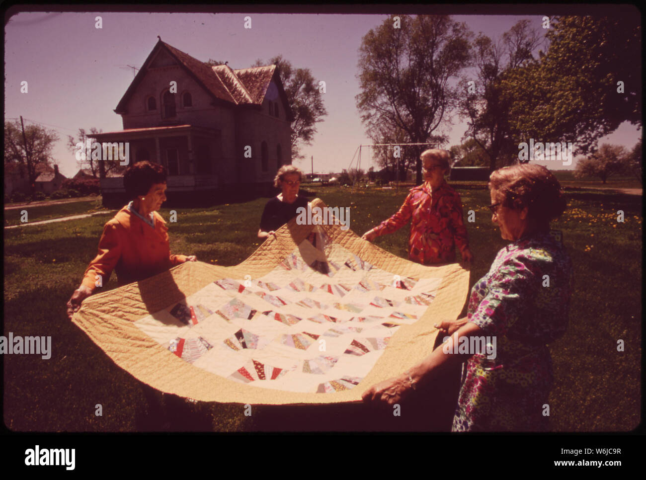 Les MEMBRES DU CERCLE D'OR DU FAIRMONT SENIOR CITIZENS CLUB TENIR QUILT qu'ils ont faites. Elle A ÉTÉ TIRÉE AU SORT LORS DU CENTENAIRE DE LA VILLE, mai 1973. Dans l'ARRIÈRE-PLAN EST LE PLUS ANCIEN BÂTIMENT DE FAIRMONT, environ 100 ans, Banque D'Images