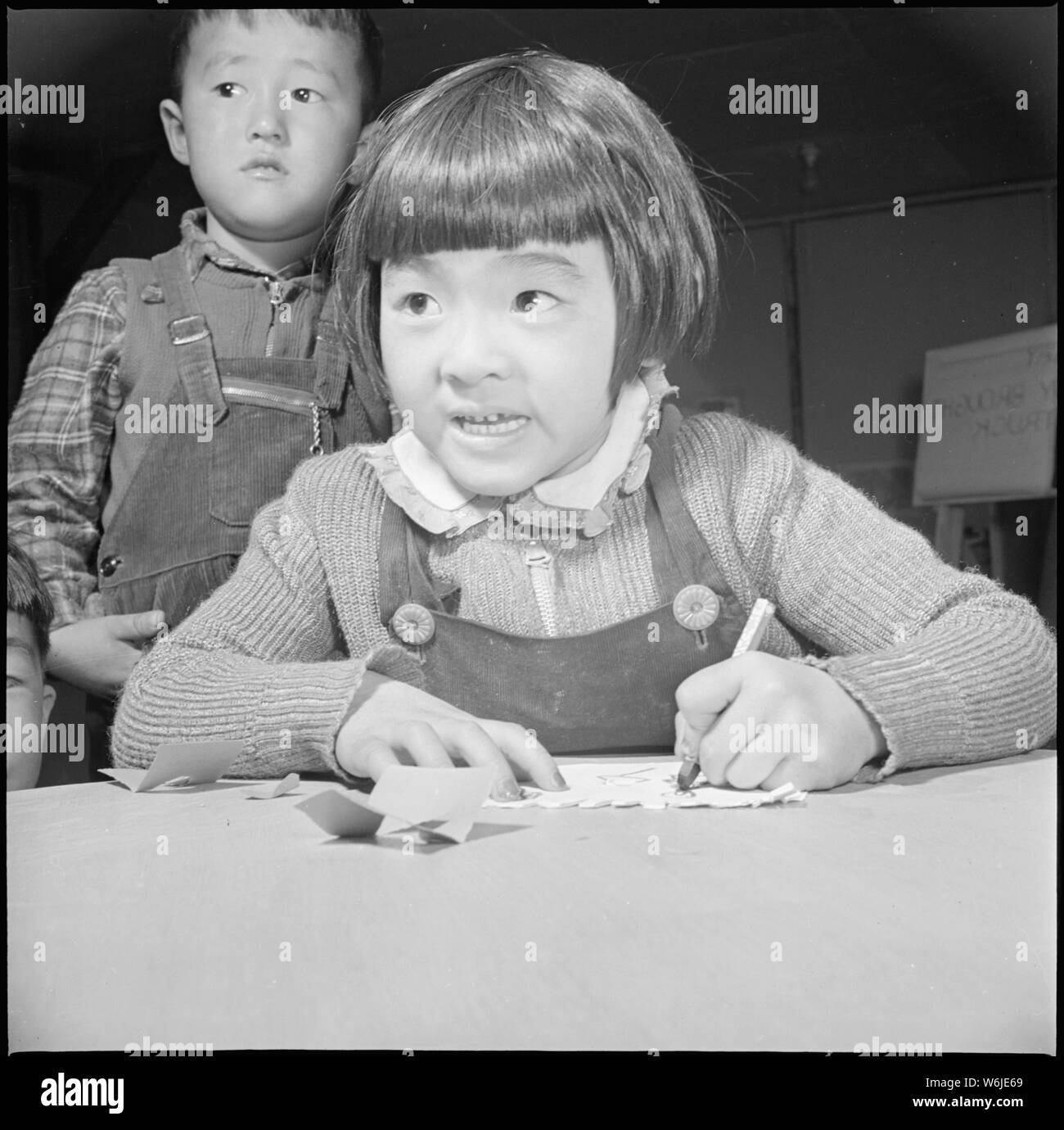 Manzanar Manzanar, Centre de réinstallation, en Californie. Une troisième année d'étudiant à l'Manzanar Relocation . . . ; Portée et contenu : la légende complète pour cette photographie se lit comme suit : Manzanar Manzanar, Centre de réinstallation, en Californie. Une troisième année d'étudiant à l'Manzanar Relocation Centre pour les sinistrés d'origine japonaise à main pratiques dessin. Cette photo a été prise dans l'étudiant centre de formation où les enseignants reçoivent des crédits universitaires pour leur enseignement pratique. Mme Kiyo Fukasawa, est l'enseignant et est supervisé par un enseignant du Caucase, comme tous les futurs enseignants. Banque D'Images