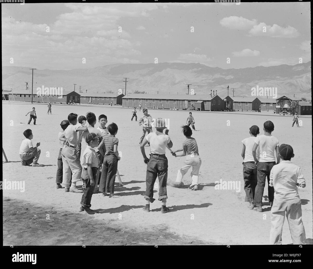 Manzanar Manzanar, Centre de réinstallation, en Californie. L'une des 80 équipes de baseball qui ont été formulaire . . . ; Portée et contenu : la légende complète pour cette photographie se lit comme suit : Manzanar Manzanar, Centre de réinstallation, en Californie. L'une des 80 équipes de baseball qui ont été formés dans les trois mois que cette guerre Autorité Relocation center a été ouvert pour les évacués d'origine japonaise. La plupart de la lecture se fait dans le coupe-feu large entre les blocs de casernes. Banque D'Images