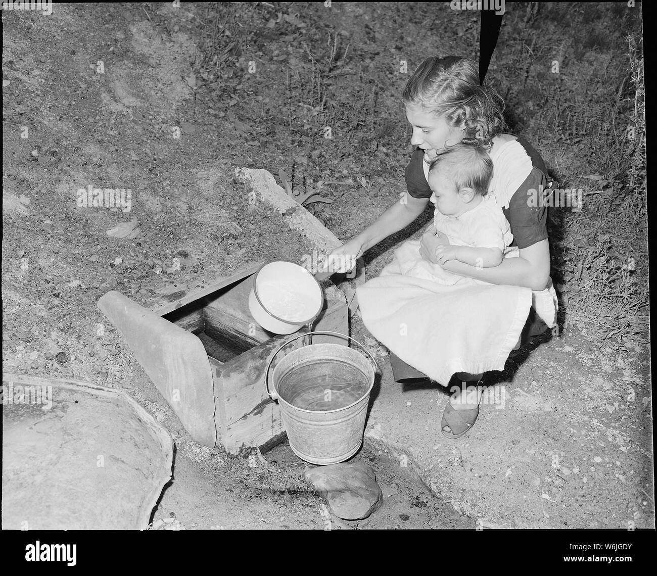 Femme de mineur obtient l'eau de s'écouler. Elle doit franchir le ruisseau et transporter de l'eau environ un quart de mille de chez elle. Le Frêne rouge Raven Coal Company, n° 2, Raven, Tazewell County, en Virginie. Banque D'Images