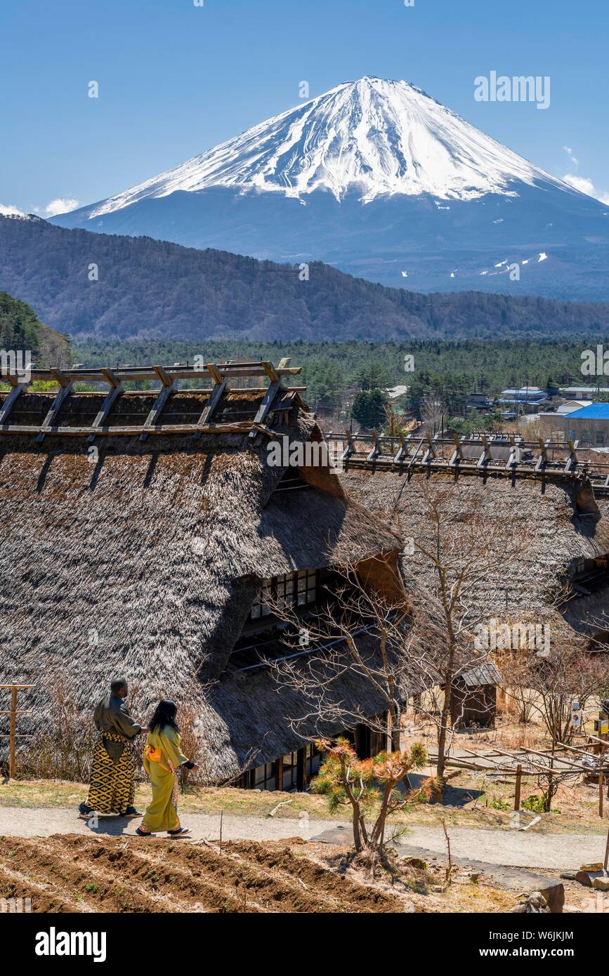 Deux personnes en kimono, musée en plein air Iyashinosato, vieux village japonais traditionnel avec des maisons d'adobe, volcan retour Mt. Fuji Fujikawaguchiko Banque D'Images