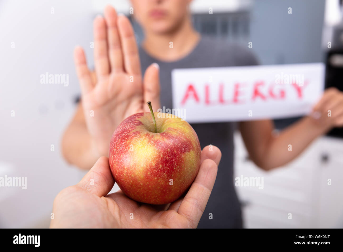 Woman Holding Apple refuse de carte d'Allergie offert par une personne à la maison Banque D'Images