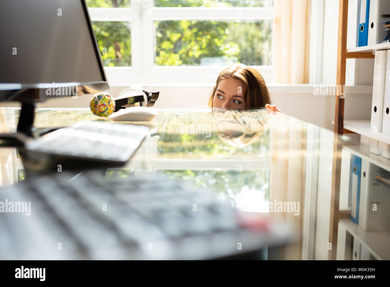 Close-up de peur Businesswoman se cacher derrière le bureau avec ordinateur portable Banque D'Images