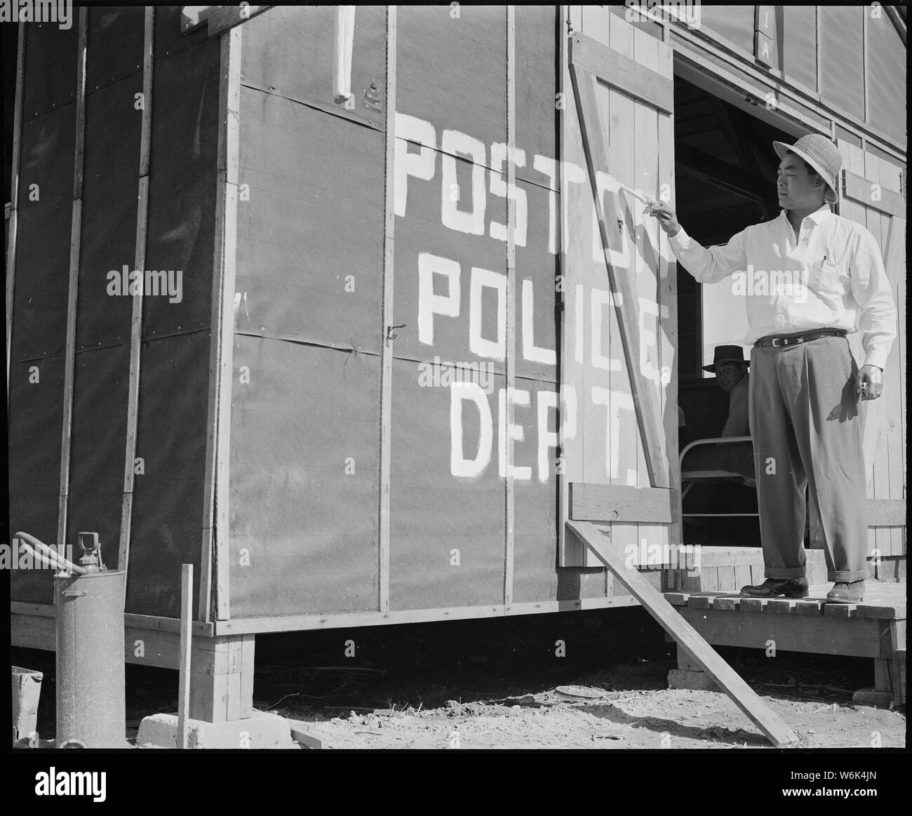 Poston, Arizona. Shigekawn le chef de la police de Kiyoshi peinture d'un signe sur premier poste de police à cette guerre . . . ; Portée et contenu : la légende complète pour cette photographie se lit comme suit : Poston, Arizona. Shigekawn le chef de la police de Kiyoshi peinture d'un signe sur premier poste de police à ce centre de compétence pour la réinstallation de guerre évacués d'origine japonaise. Banque D'Images