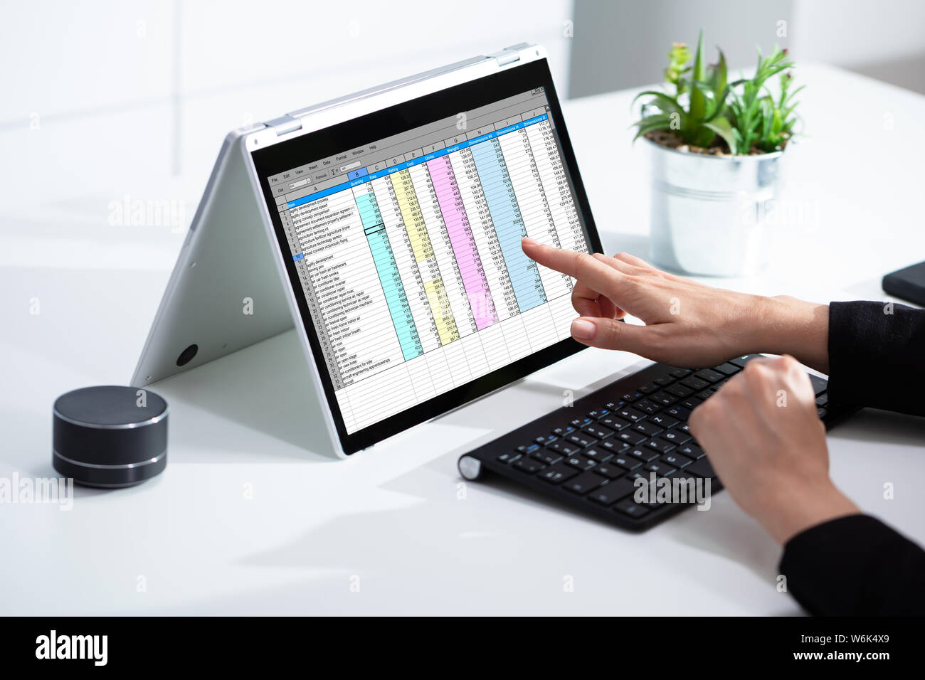 Close-up of a woman's Hand l'examen Excel sur Laptop In Office Banque D'Images