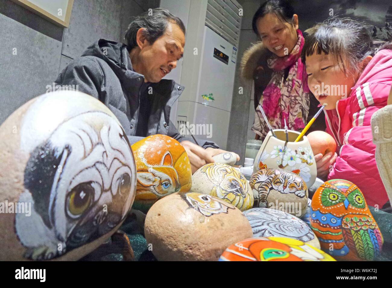 Dans cette photo non datée, artisan crée mignon chien peintures sur la surface des pierres dans la ville de Puyang, province du Henan en Chine centrale. Banque D'Images
