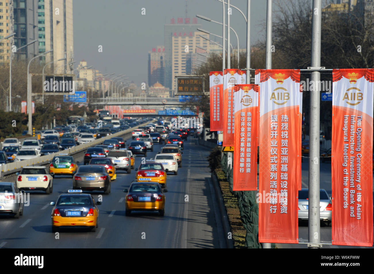 --FILE--voitures passent par la publicité des bannières de la cérémonie d'ouverture de l'Asian Infrastructure Investment Bank (AIIB) et première réunion des conseils d'un Banque D'Images