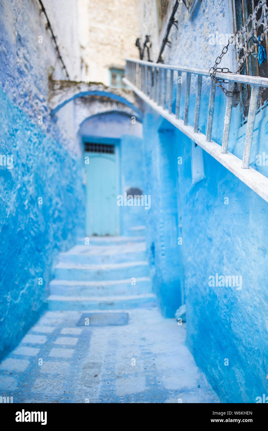(Selective focus) avec une vue magnifique sur une ruelle étroite avec la substitution, bleu bâtiments blanchis à la chaux. Banque D'Images