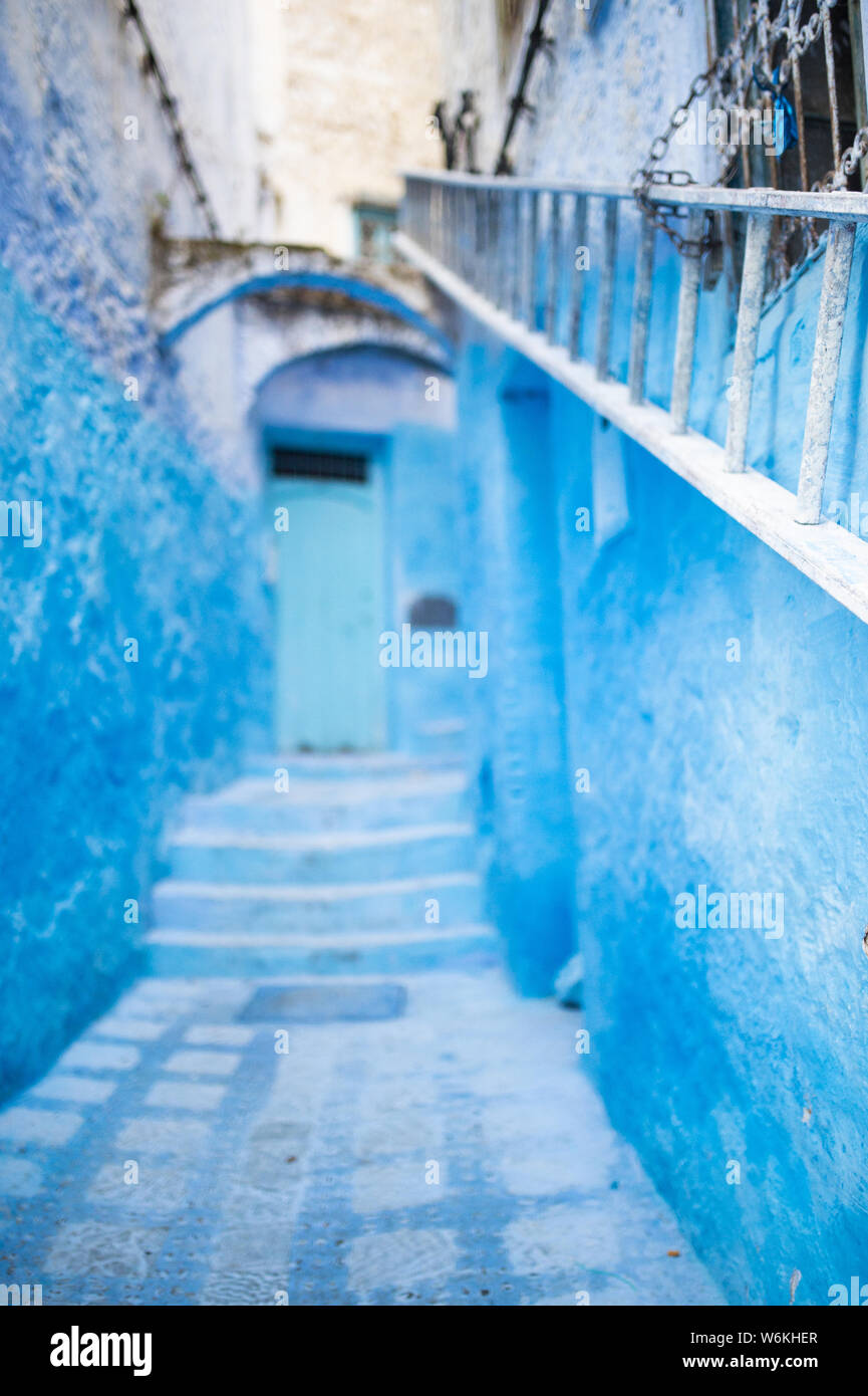 (Selective focus) avec une vue magnifique sur une ruelle étroite avec la substitution, bleu bâtiments blanchis à la chaux. Banque D'Images