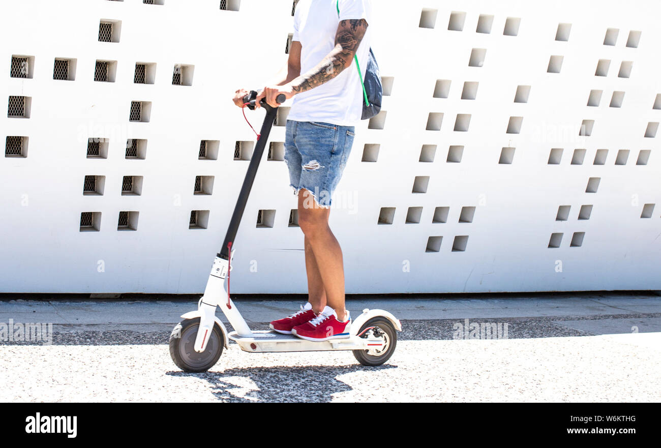 Malaga, Espagne - Juillet 9th, 2018 le jeune homme : driving electric scooters coup près de centre Pompidou Musée, Malaga, Espagne Banque D'Images