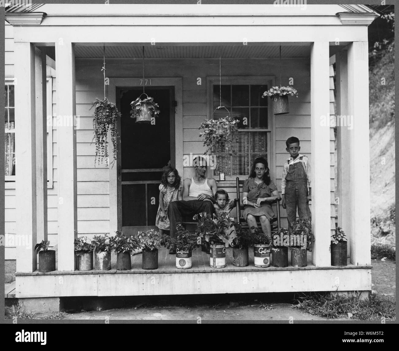 T. J. Martin, mineur, et de la famille sur le porche avant de leur maison. M. Martin est arrivé ici il y a 13 mois. A économisé assez d'argent pour retourner à Floyd Company, New York, où il sera de nouveau sur sa propre ferme. Koppers Division du charbon, Kopperston Kopperston, mines, Wyoming County, Virginie occidentale. Banque D'Images