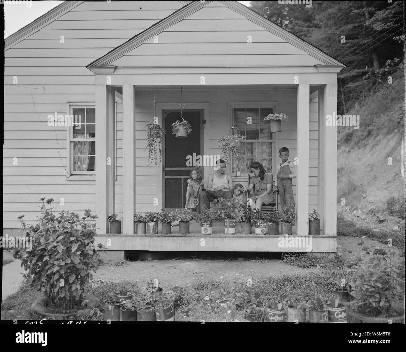 T. J. Martin, mineur, et de la famille sur le porche avant de leur maison. M. Martin est arrivé ici il y a 13 mois. A économisé assez d'argent pour retourner à Floyd County, New York., où il sera de nouveau sur sa propre ferme. Koppers Division du charbon, Kopperston Kopperston, Mines, Wyoming County, Virginie occidentale. Banque D'Images