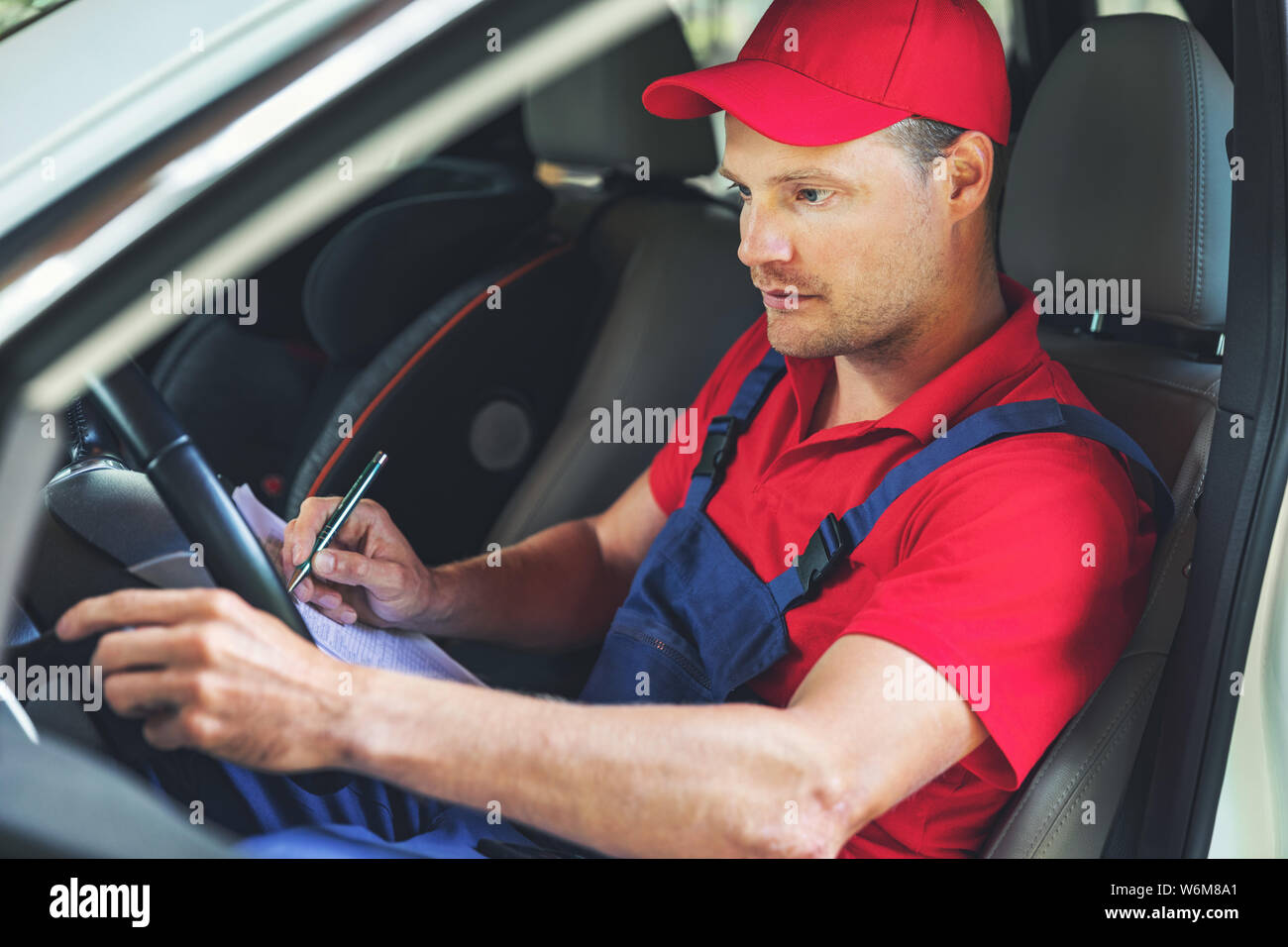 L'inspection technique du véhicule - mechanic assis à l'intérieur de la voiture et panneau de contrôle Banque D'Images
