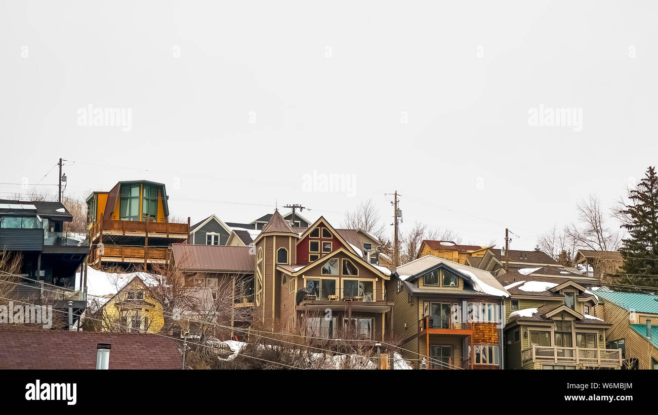 Panorama Hill maisons avec balcons et toits enneigés contre ciel nuageux en hiver Banque D'Images