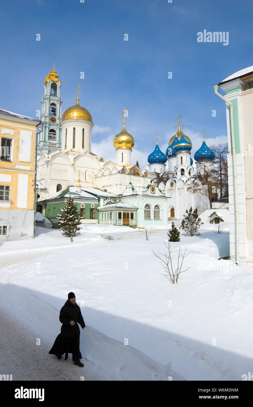 Moine orthodoxe se déplacer dans la neige contre une église. La Laure de la trinité Saint-serge, Russie St. Banque D'Images