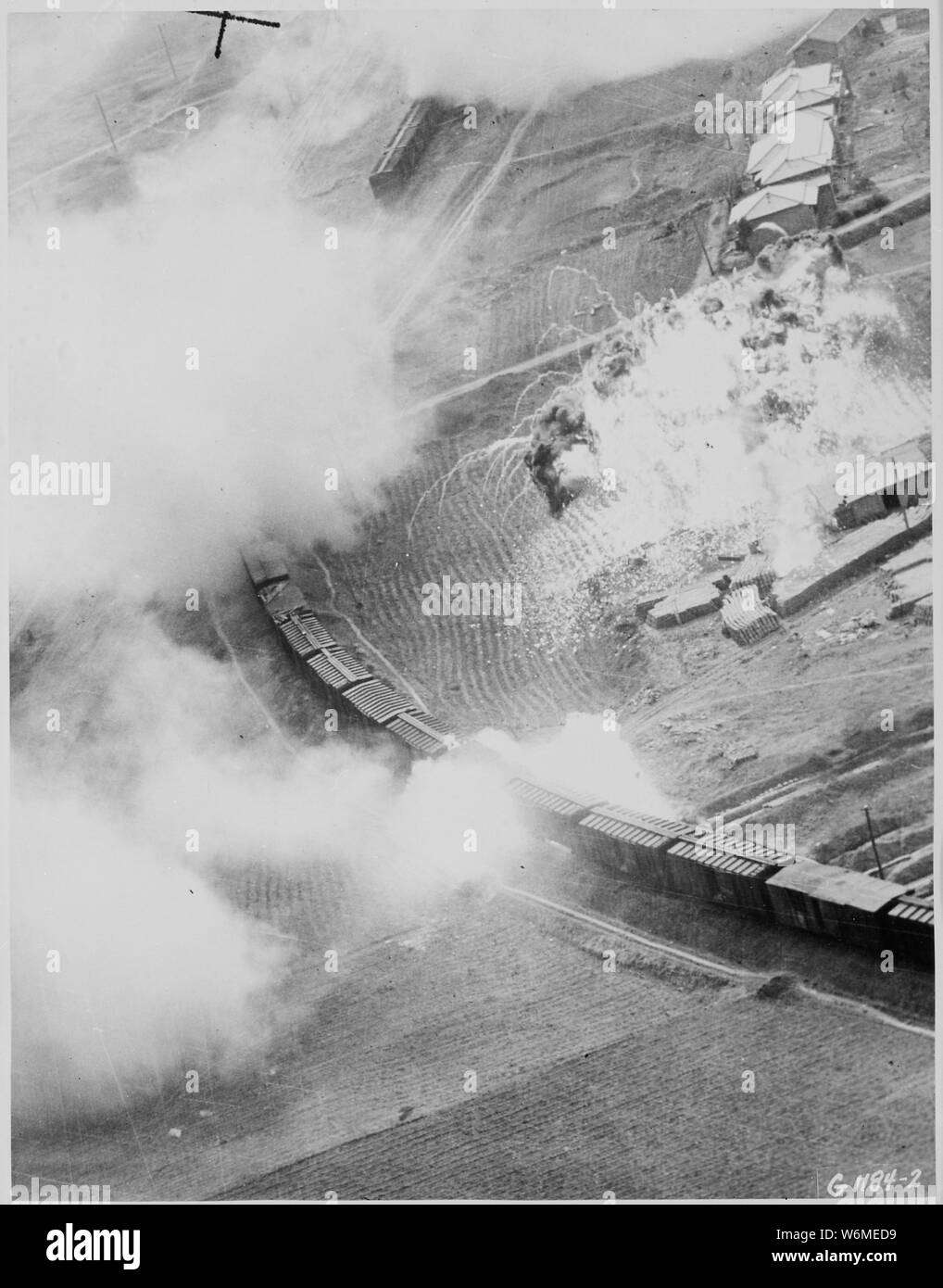 Le réservoir de napalm a chuté de cinquième Air Force B-26 Invader bombardiers légers du 452e Bomb Wing (léger) sur cette gare de triage rouge à Masen-ni, Corée du Nord, a mélangé avec un stock de fournitures sur une plate-forme de chargement à partir d'un brasier ardent ; Portée et contenu : le réservoir de napalm a chuté de cinquième Air Force B-26 Invader bombardiers légers du 452e Bomb Wing (léger) sur cette gare de triage rouge à Masen-ni, Corée du Nord, a mélangé avec un stock de fournitures sur une plate-forme de chargement d'un immeuble en brasier. Une fusée qui a percé un wagon couvert chargé avec des approvisionnements s'est fixé deux autres abl Banque D'Images