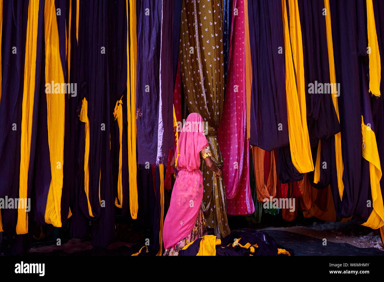 L'Inde, Rajasthan, Sari, usine textile sont séchés à l'air libre. La collecte des textiles à sec sont pliées par les femmes Banque D'Images