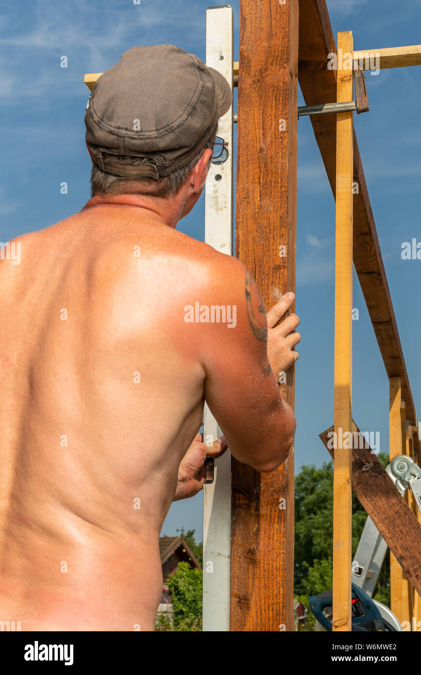 Mesures Un artisan une poutre en bois avec un niveau de l'esprit Banque D'Images