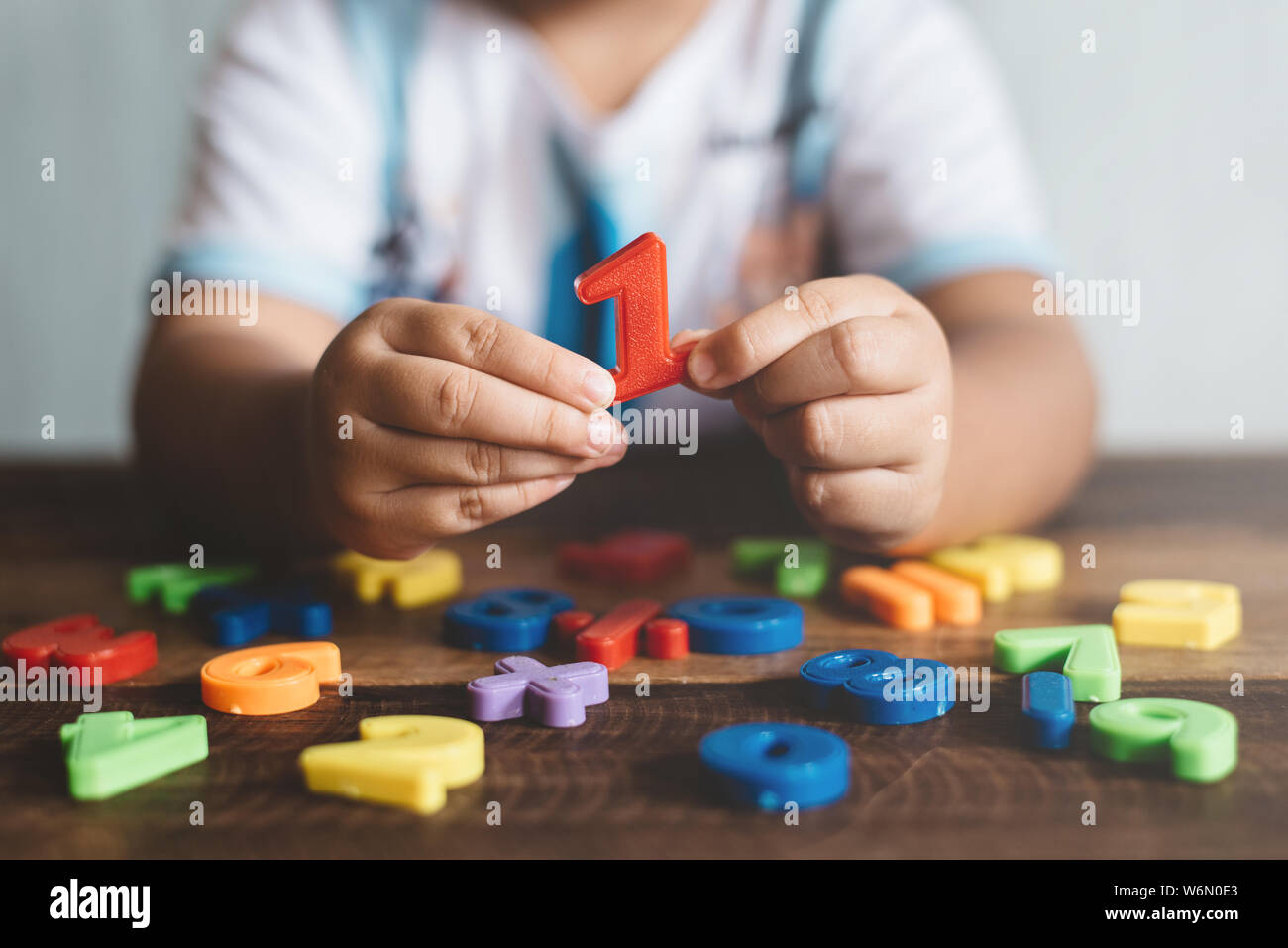 Enfant tenant un certain nombre de jouets en plastique, il est apprendre à compter. Concept de l'éducation des enfants et de croissance de l'enfant Banque D'Images