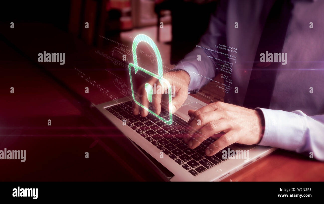 Man typing on laptop avec écran holographique cadenas sur clavier. La cybersécurité, la protection de l'ordinateur et internet concept de sécurité. Banque D'Images