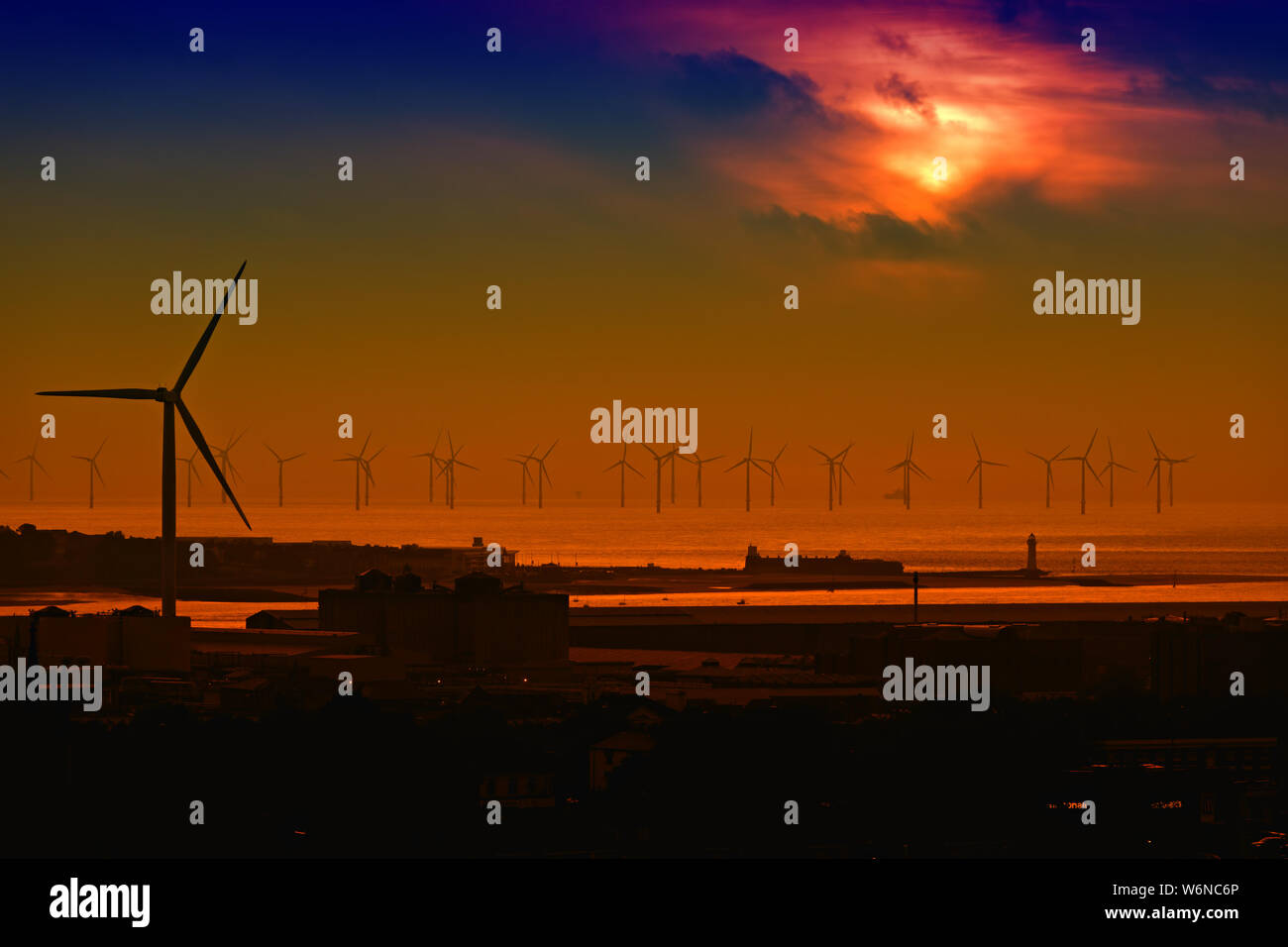 Burbo turbines éoliennes en mer Banque de la baie Liverpool en silhouette contre le ciel d'un beau coucher du soleil. Banque D'Images