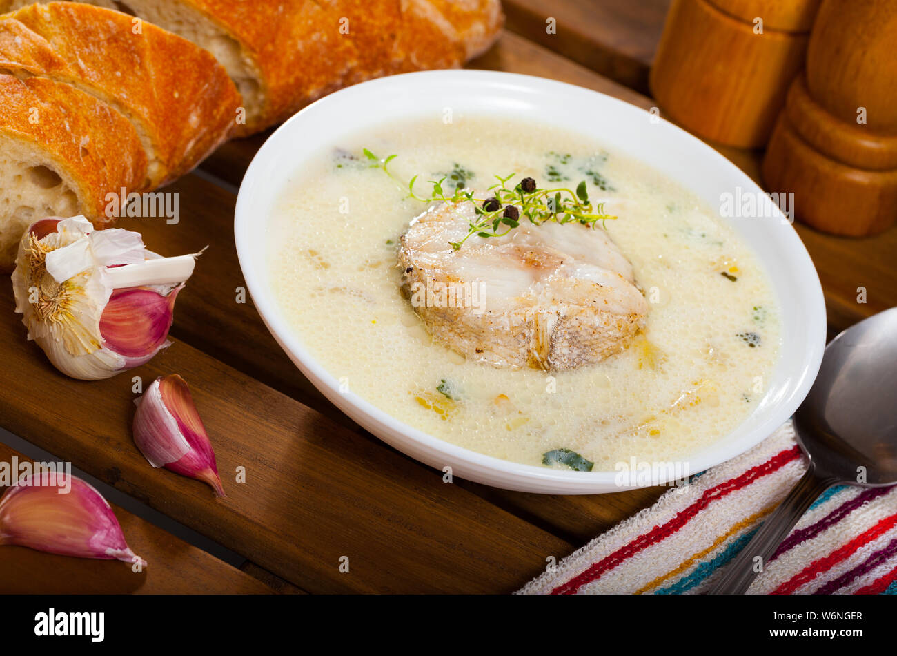 Soupe de morue délicieux dans un bol blanc avec baguette garnie de microgreens Banque D'Images