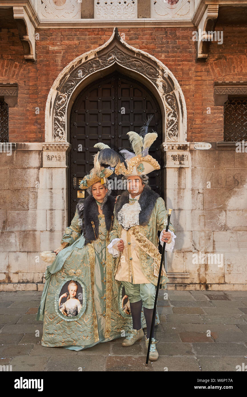 Masques de Venise se tient devant la porte verte à Venise, Italie Banque D'Images