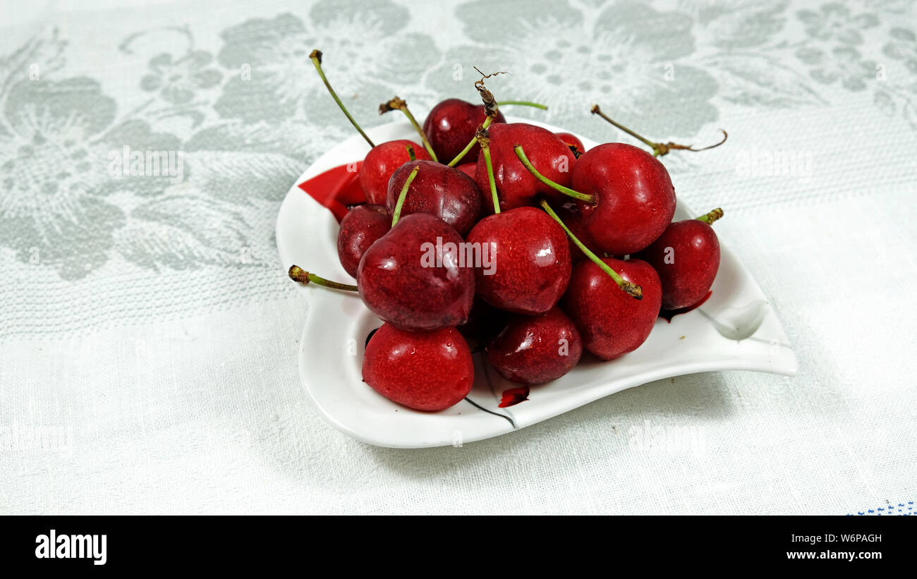 Cerises sur la plaque coeur Banque D'Images