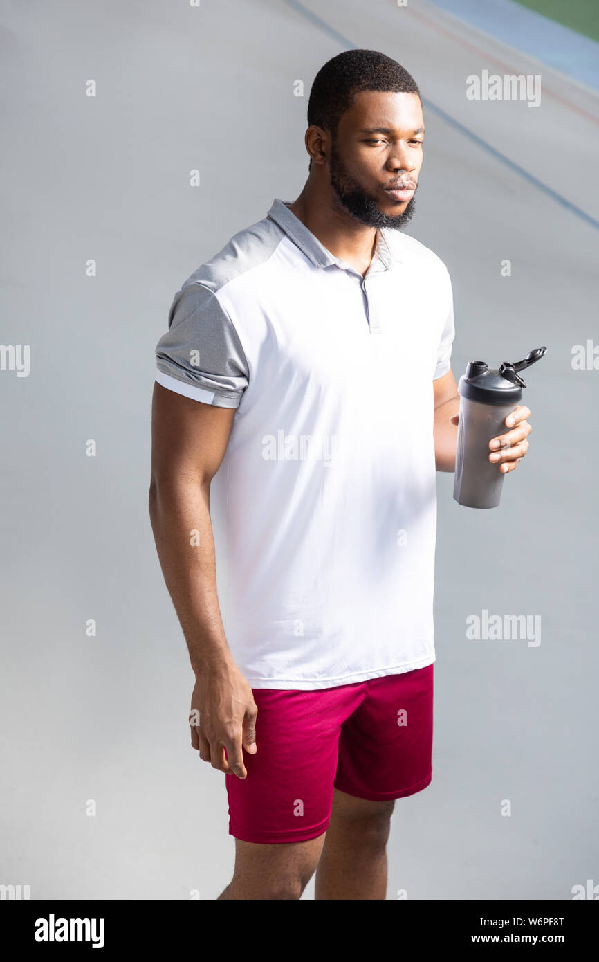 Jeune homme tenant une bouteille d'eau sport en plastique Banque D'Images