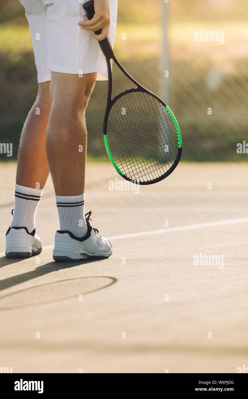 Cropped shot de sportif, avec la raquette sur un court de tennis. Un joueur de tennis sur surface dure de base. Banque D'Images