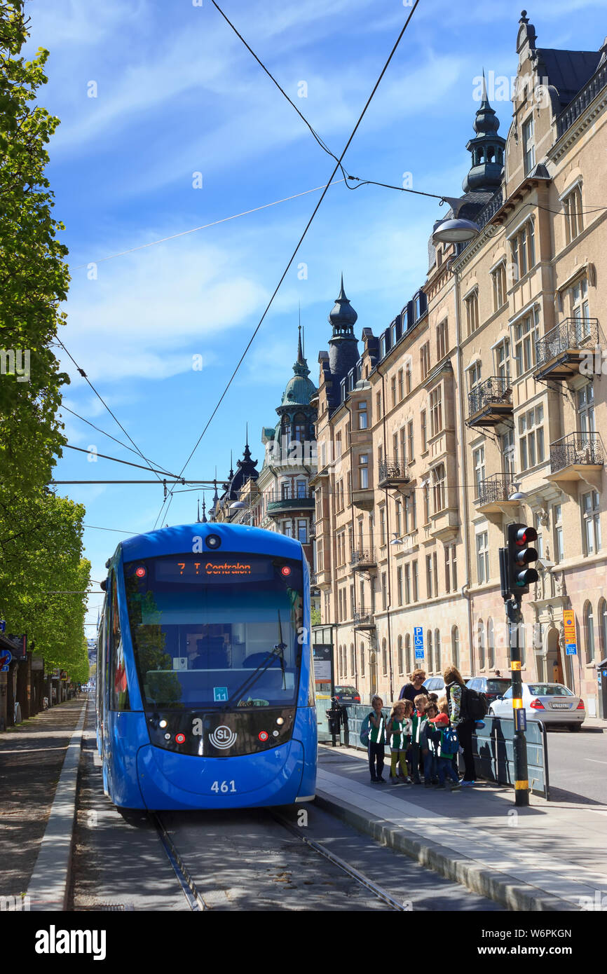 Storstockholms Lokaltrafik SL ou tramway bleu et les passagers en attente à un arrêt à STHLM (Östermalmstorg). Réseau de transport public suédois. Banque D'Images
