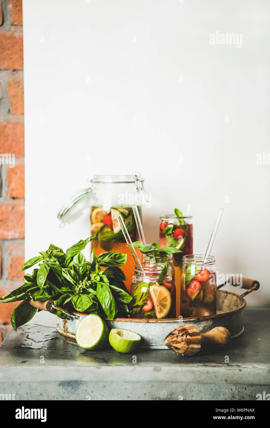 Fraises fraîches maison basilic et glace limonade ou plateau en verre double paroi avec eco-friendly pailles plastique sur le plateau métallique rustique, mur blanc à la ba Banque D'Images